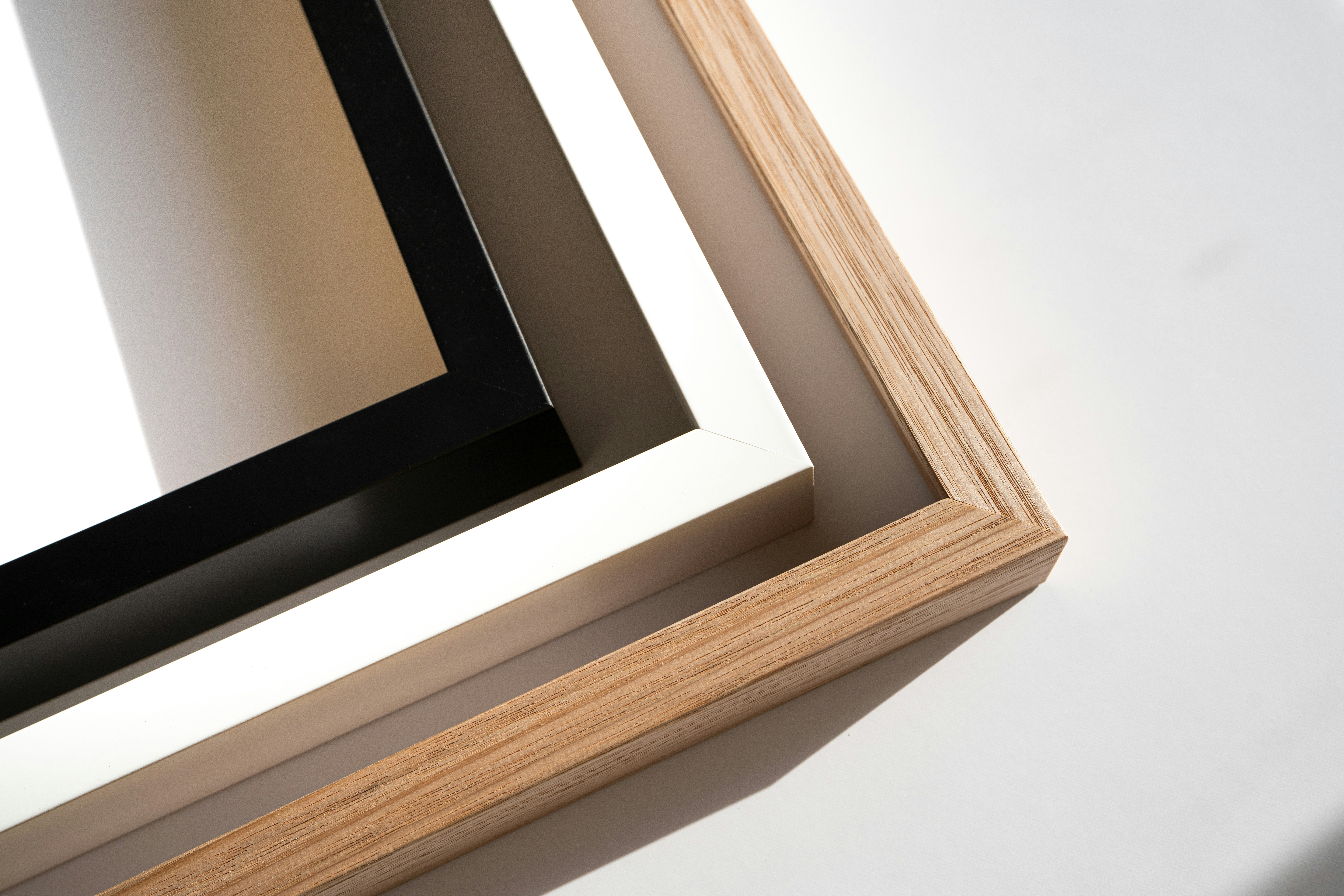 Close-up of oak wood, white, and black frame corners, showing construction