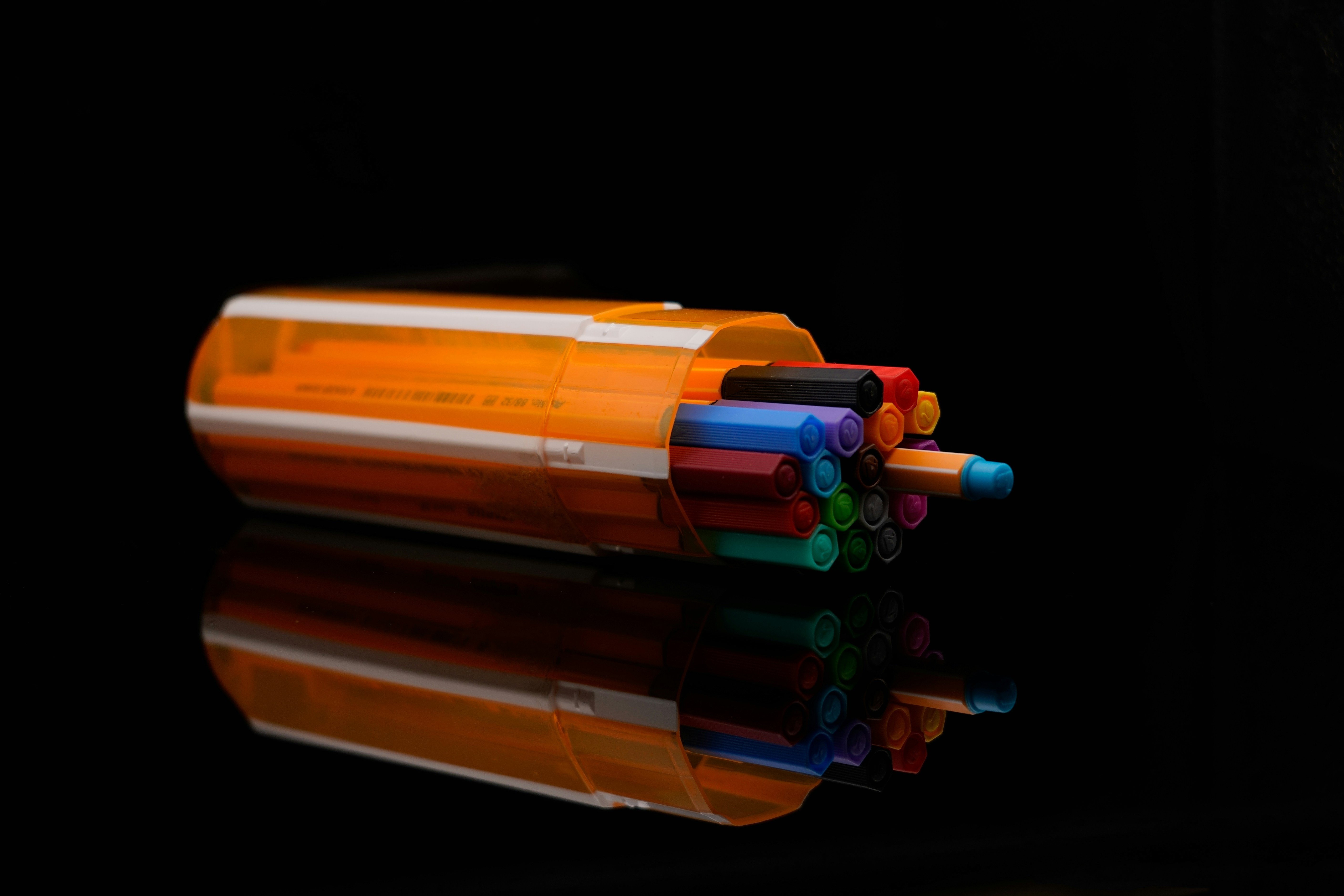 A group of colorful pencils lies on a wooden table, symbolizing the creative