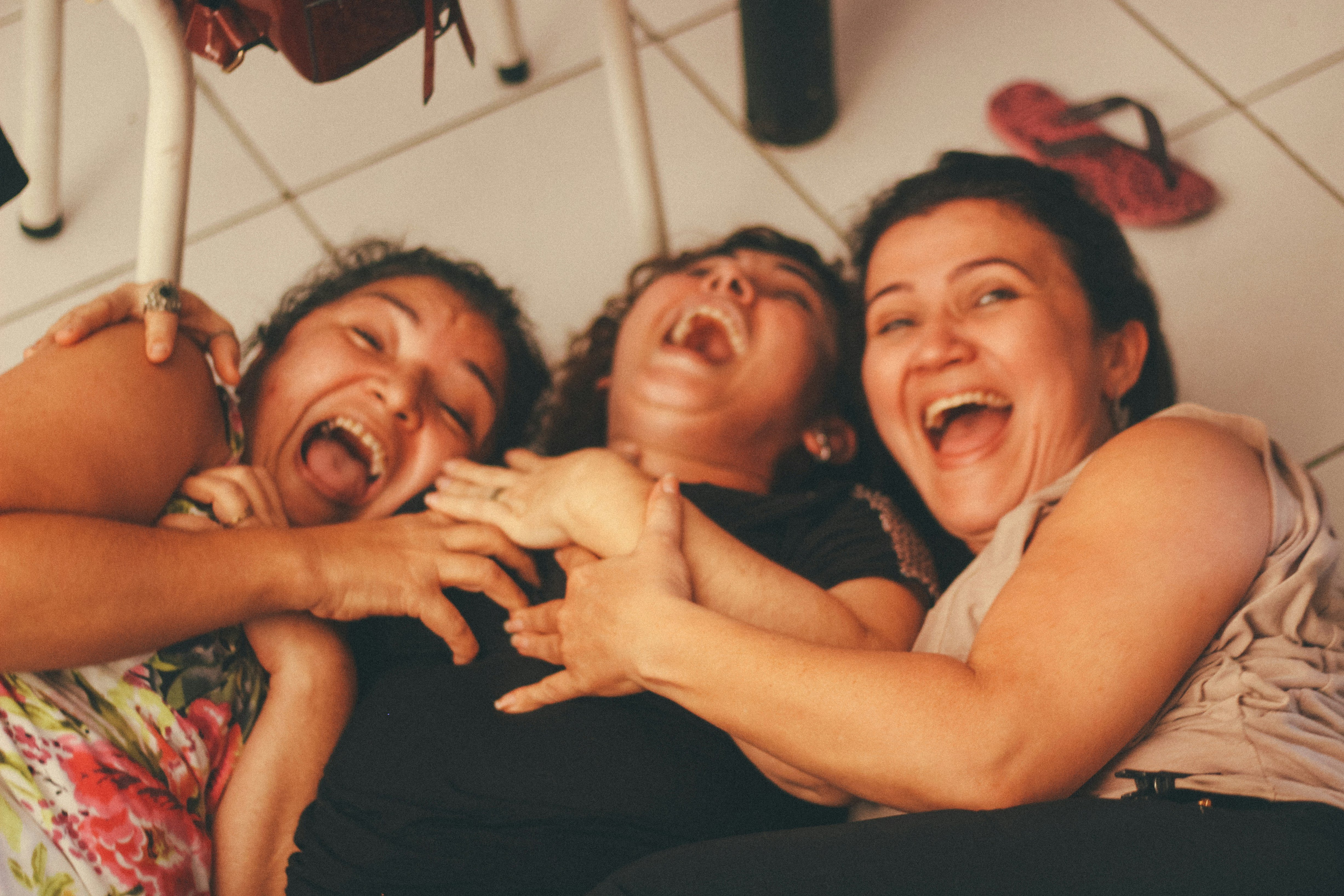 Drie lachende vrouwen staan samen, inspirerend en
